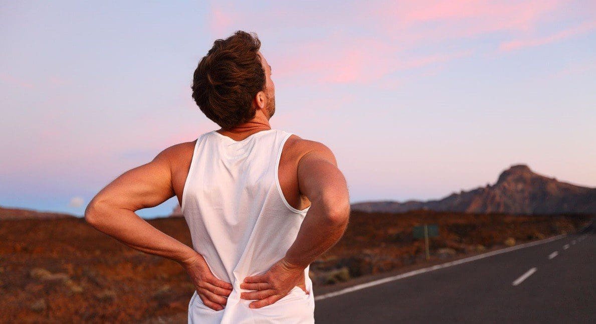 A runner pauses because of back pain.