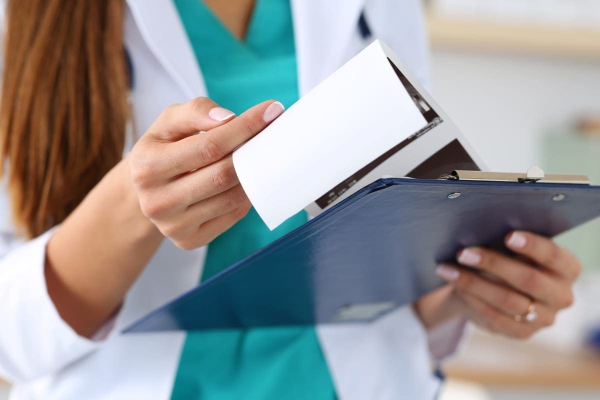 A chiropractor holding a clip board.