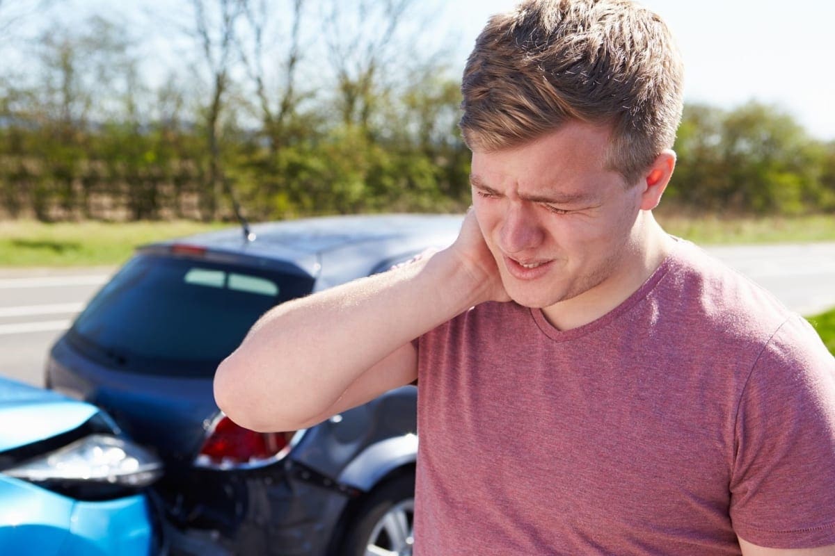 A man is suffering from whiplash pain after an accident.