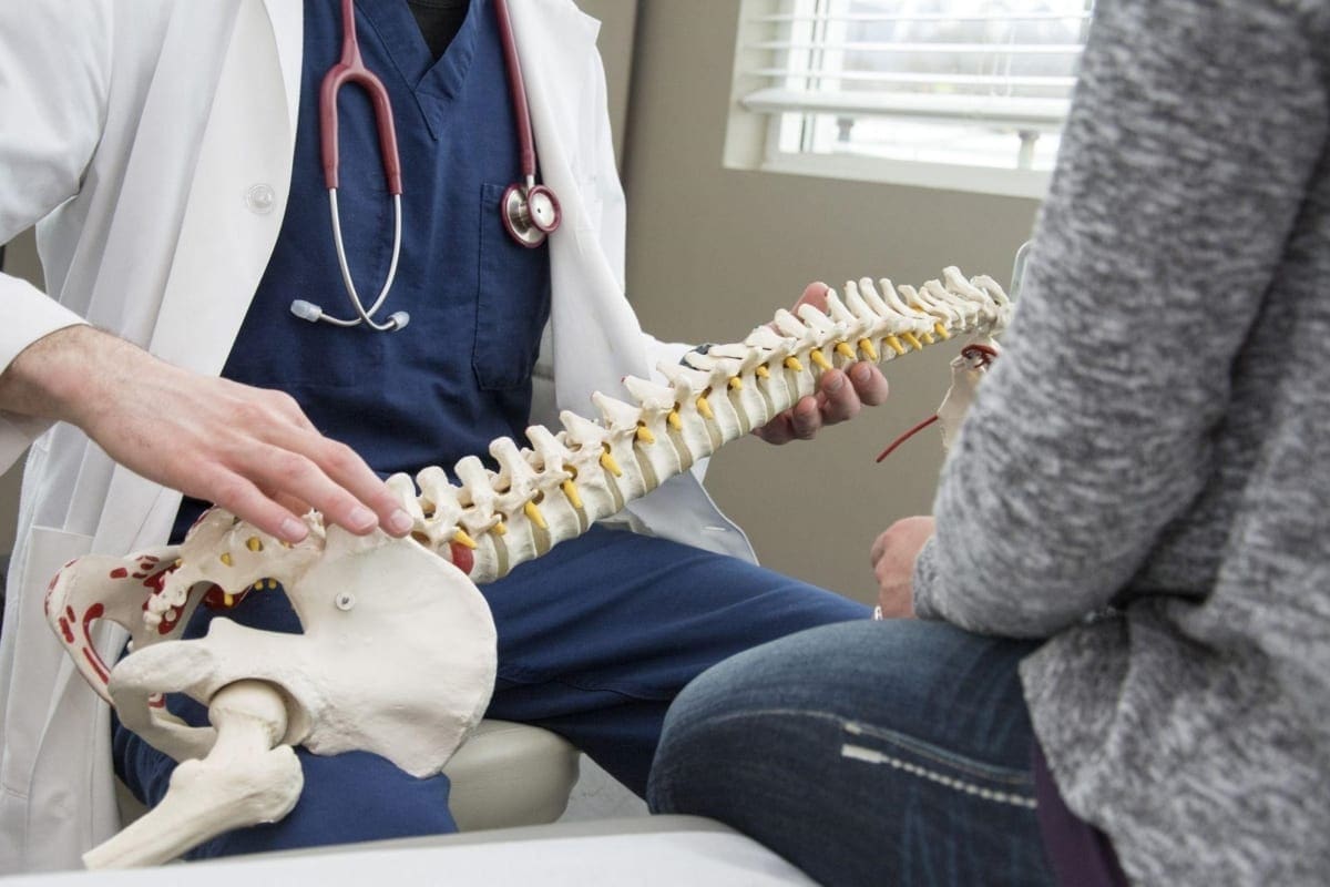 A chiropractor answers a patients questions and explains treatments.