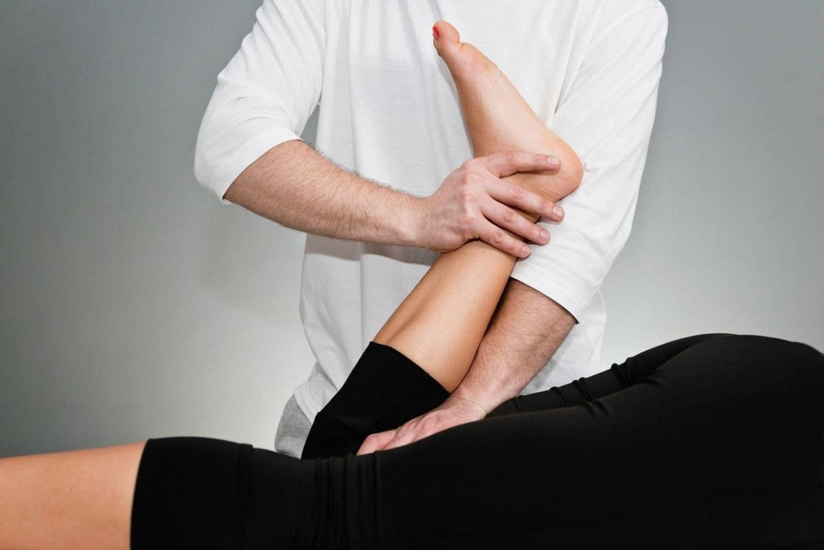 A chiropractor is administering a leg adjustment