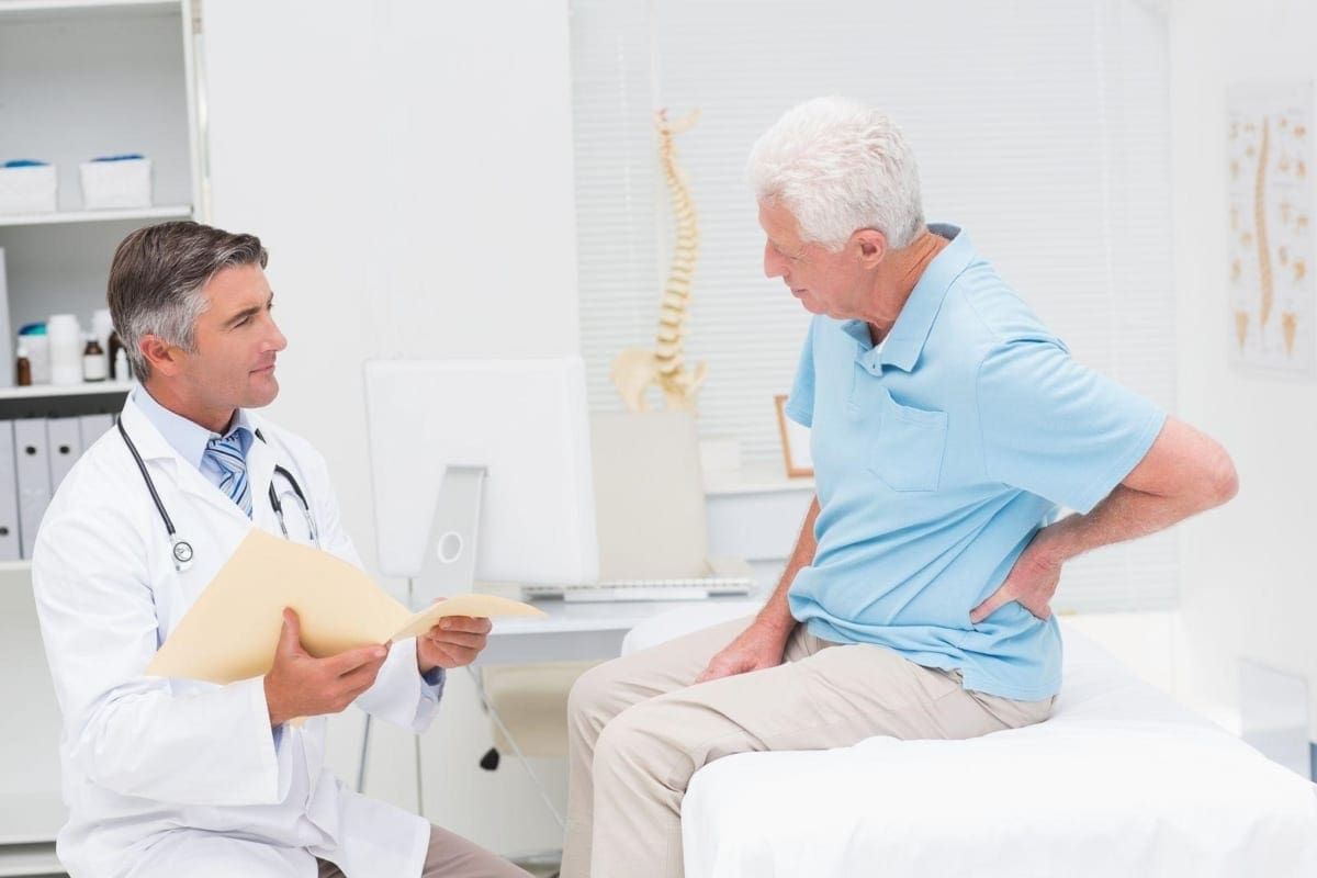 A chiropractor discusses back pain treatment options with a patient.