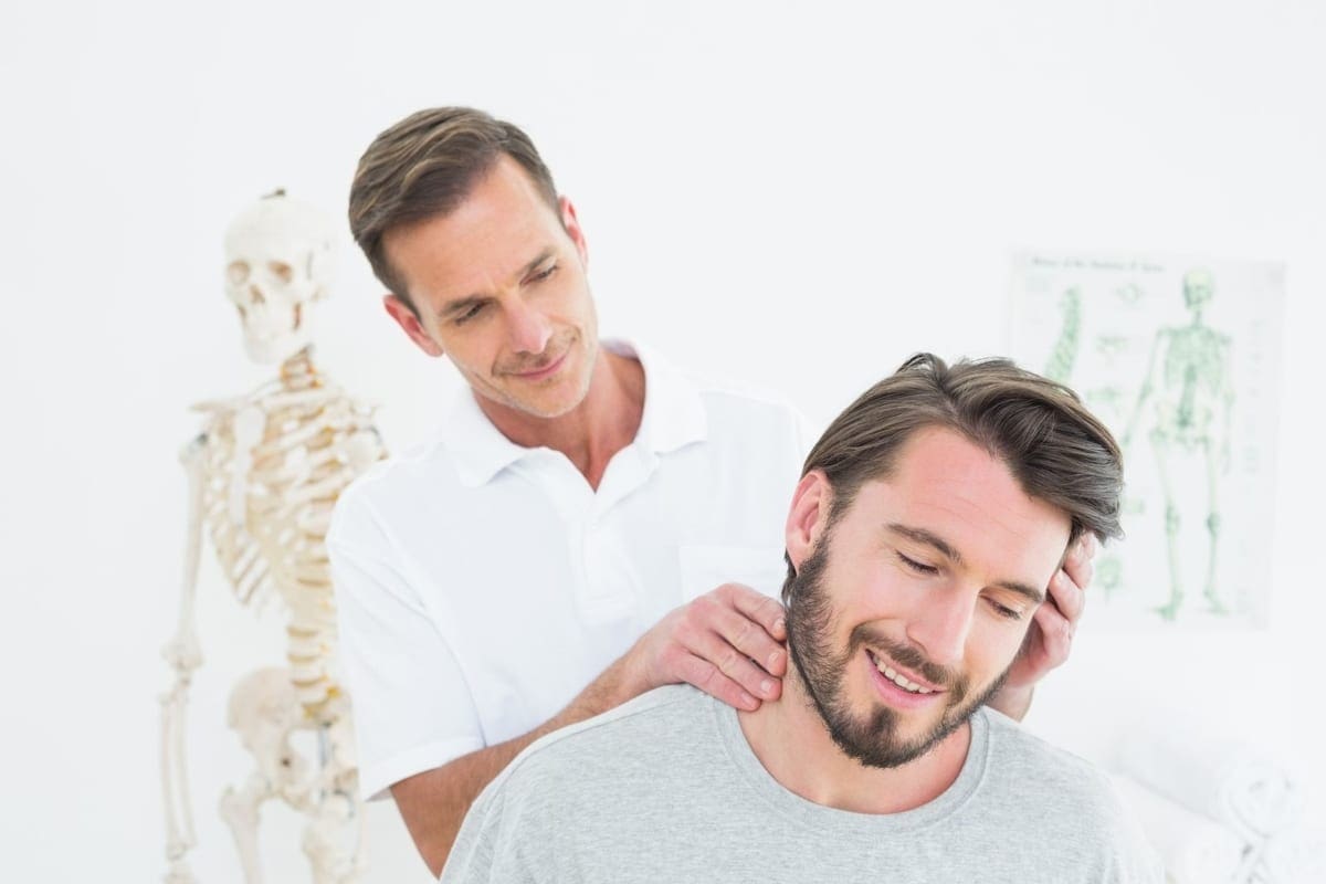 A man is happy from the pain relief he is experiencing from chiropractic neck adjustments.