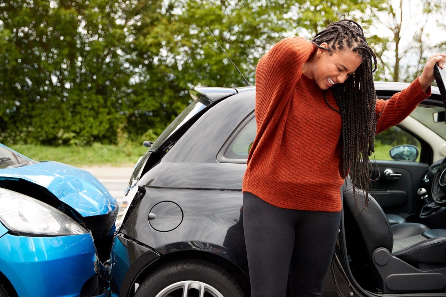 A woman grabs the back of her neck in pain after being in a car accident in Hillsboro, OR.