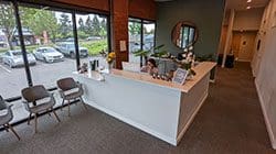 Clackamas Chiropractic clinic reception area with large windows and a friendly receptionist.