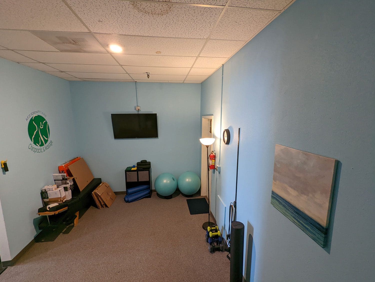 Physical therapy treatment room with light blue walls and physical therapy equipment.