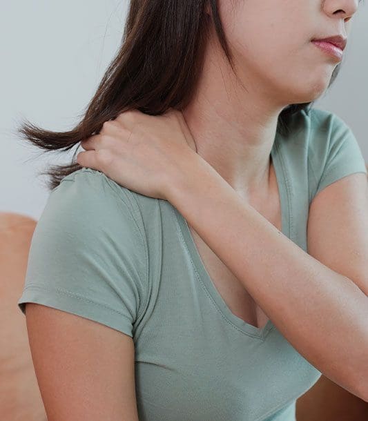 A woman massages her left shoulder because of shoulder pain.