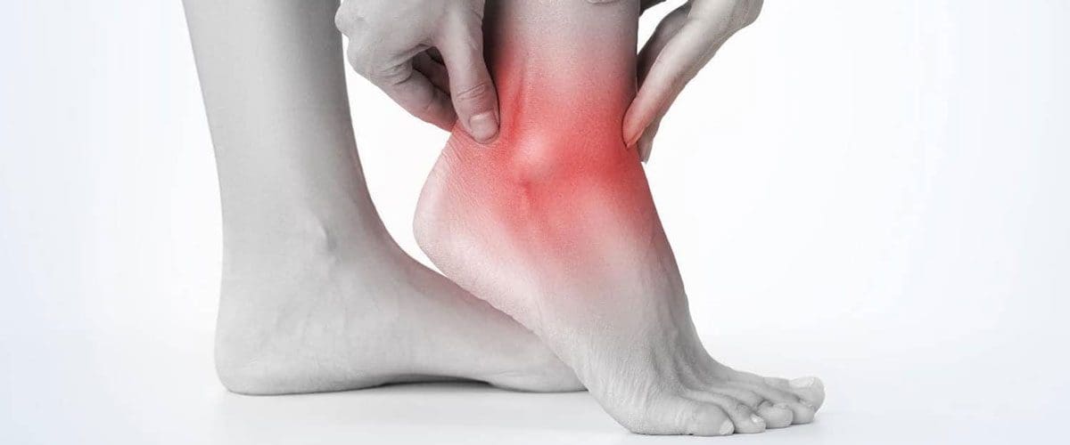 Ankle Pain | Woman grabbing her ankle
