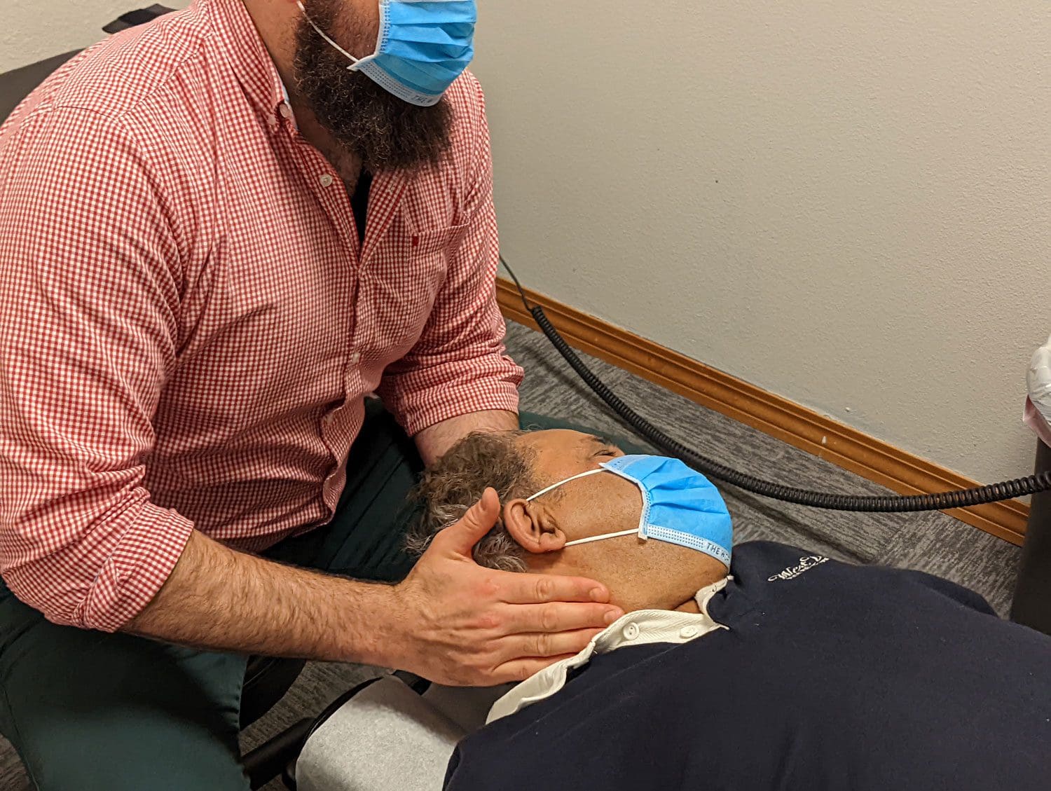 A chiropractor is administering a neck adjustment on a patient at Beaverton's Accident Care Chiropractic clinic.