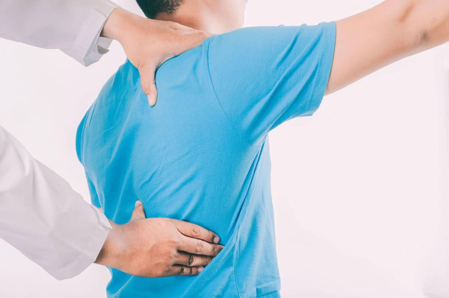 A man in a blue shirt receiving chiropractic treatment after a car accident.