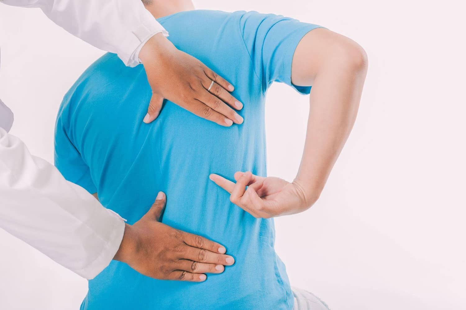 A man points to where his back hurts, during a chiropractic exam.