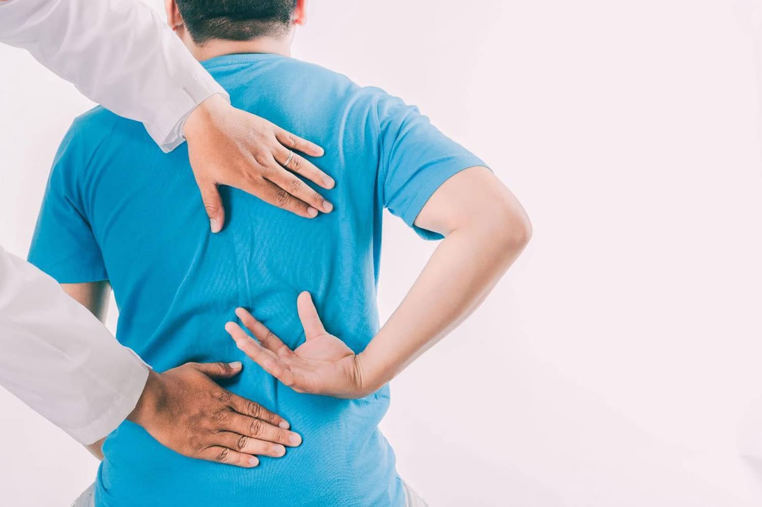 A man points to where his back hurts, during a chiropractic exam.