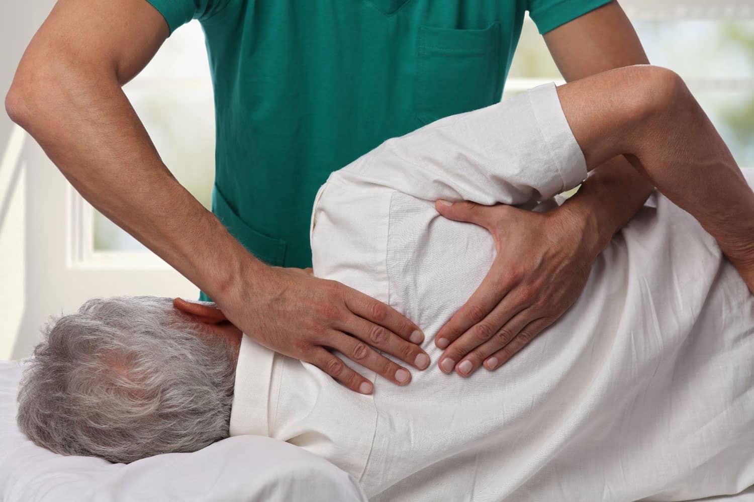 A man is laying on a chiropractic table, getting a chiropractic adjustment for post accident recovery.