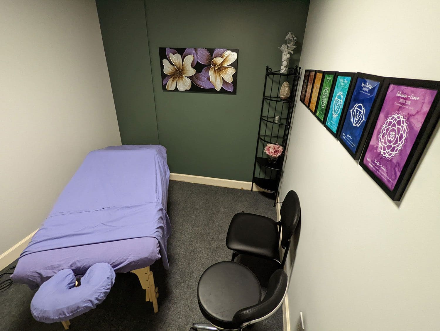 Northeast Portland Chiropractic clinic's massage therapy room with green walls and floral wall art.