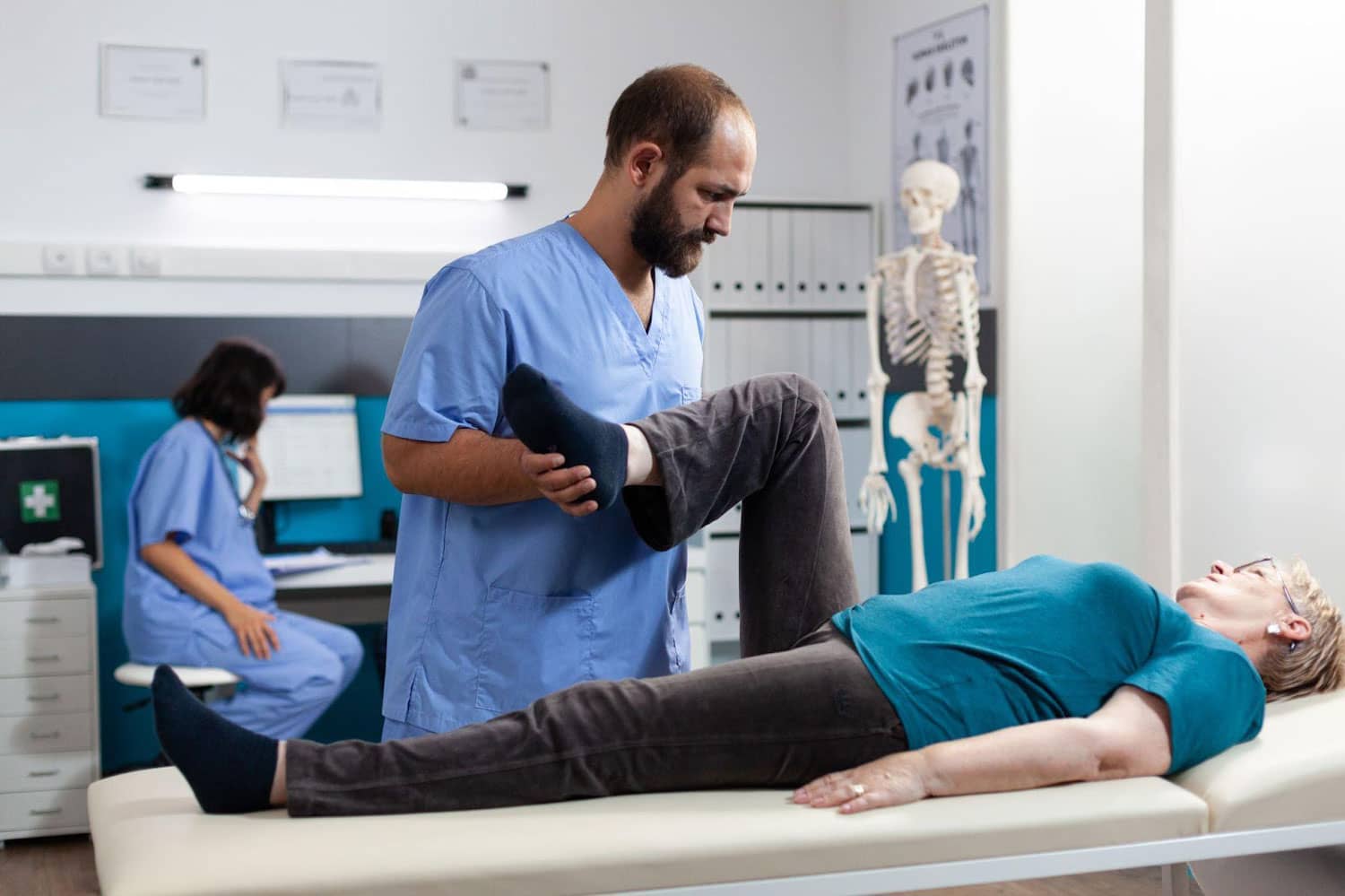 A woman is laying on her back on a chiropractic table, getting an adjustment after car accident injuries.