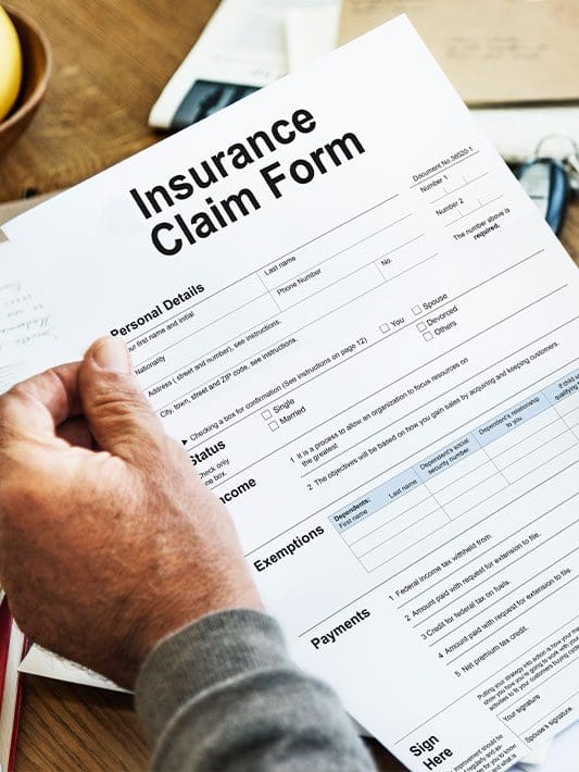 A man is holding an insurance form.