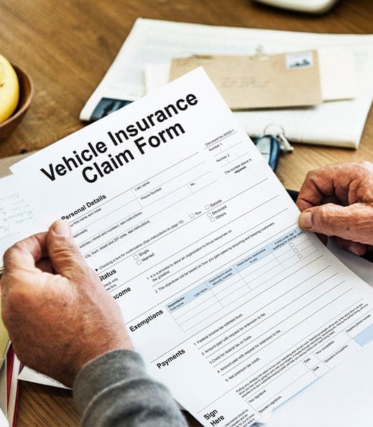 A man his reviewing a vehicle insurance claim form.