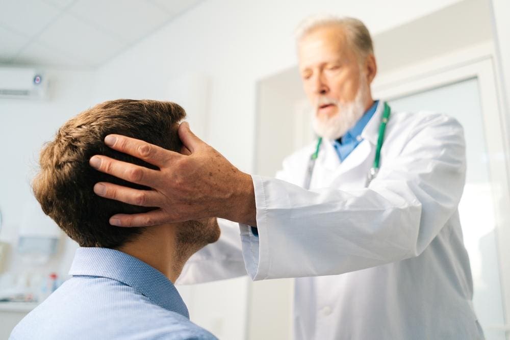 A chiropractor is treating a man for migraine headaches.