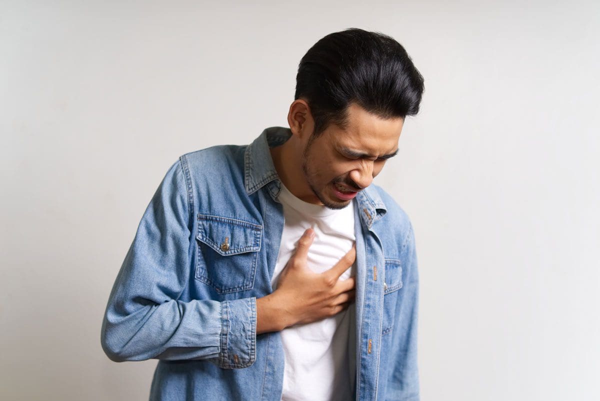 A young man grimacing from chest pain.