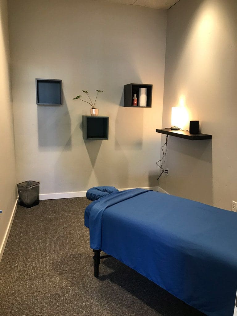 Bend Clinic massage therapy room with massage table and wall decorations