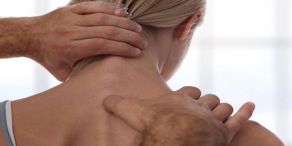 A chiropractor is treating a woman for neck pain.