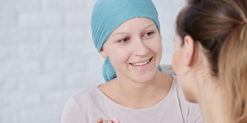 A woman is speaking with a chiropractor after a chemotherapy treatment.