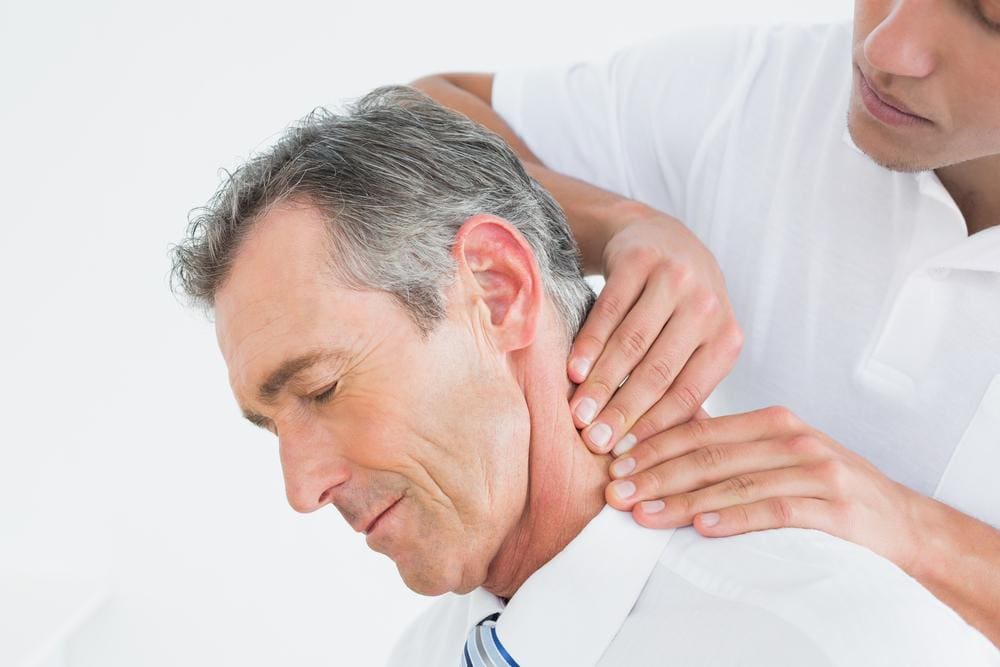 A man is getting chiropractic care after a stroke.