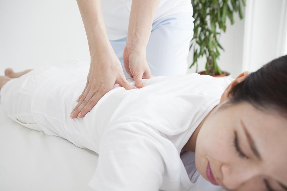 A woman is getting a chiropractic adjustment to alleviate post epidural discomfort. 