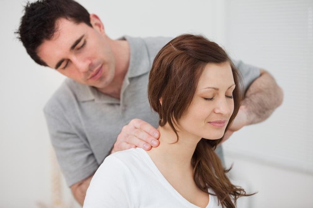 I chiropractor is treating a woman for symptoms of stress. 
