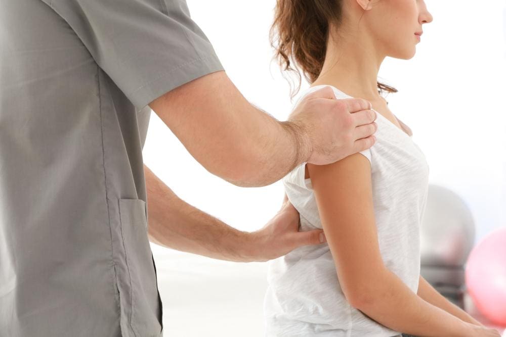 a woman is seeing a chiropractor to treat chronic pain. 