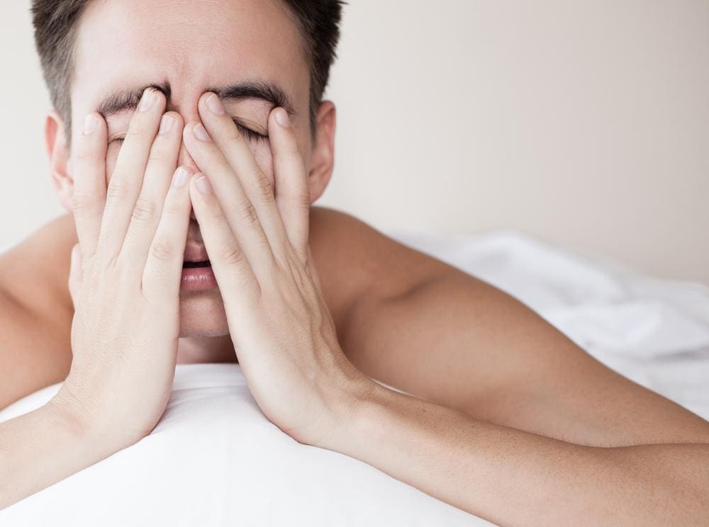 A man suffering from sleep apnea, is lying in bed and stressing, because he can't sleep.
