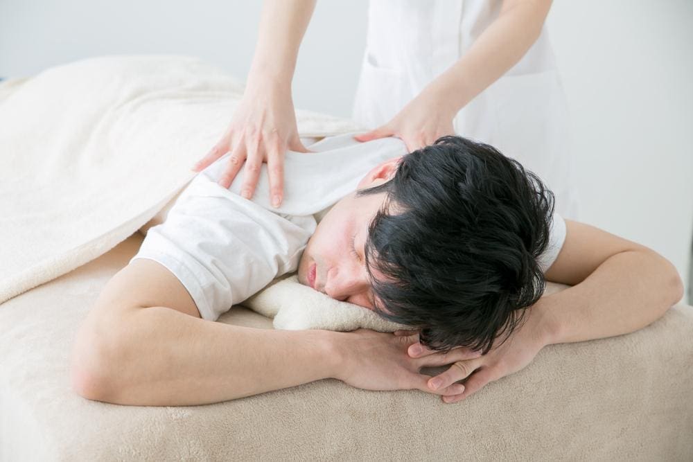A young man with a herniated disc is being treated by a chiropractor for pain. 
