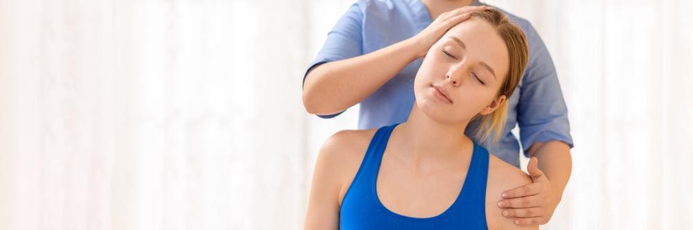 A chiropractor is treating a young woman for concussion symptoms. 