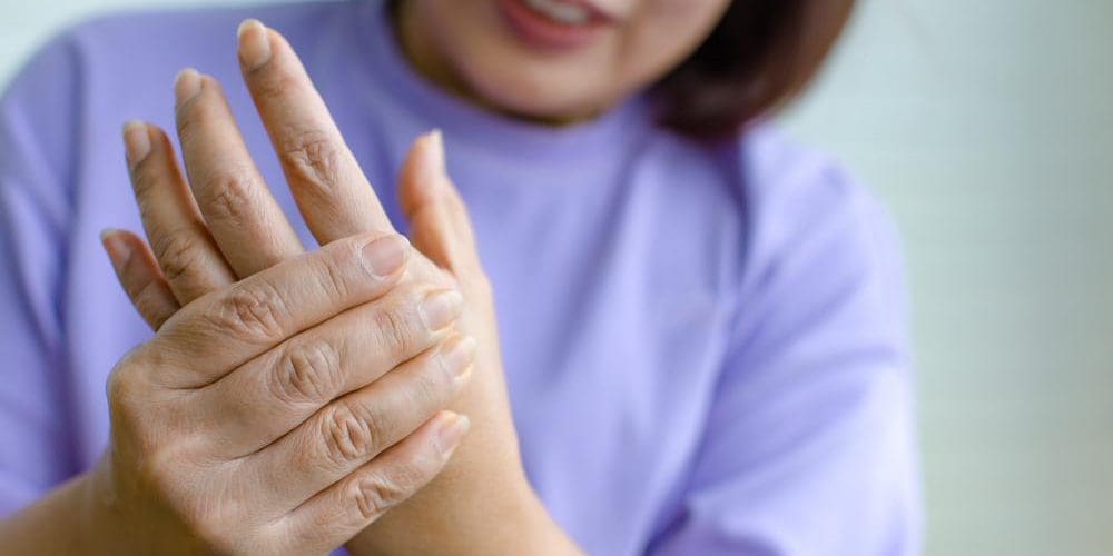 A woman is clutching her left hand because it is numb.