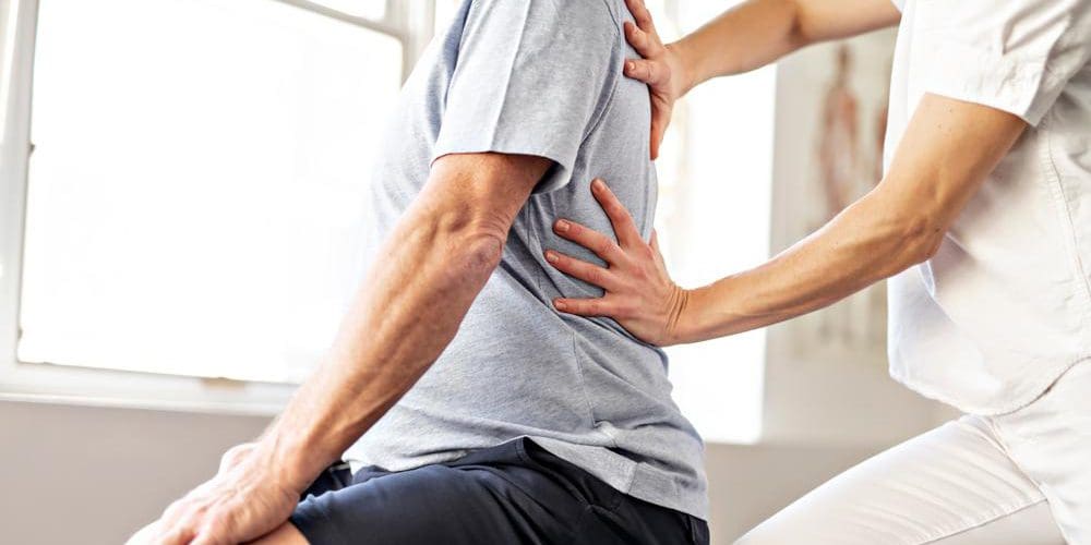 A chiropractor is treating a man for herniated disc pain.
