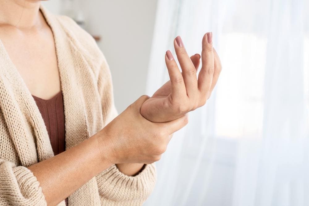 A woman is rubbing her left wrist because her hand has gone numb. 