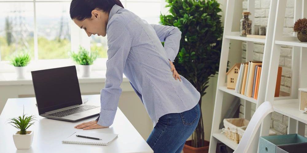 A woman cannot stand up straight because of sciatica pain.