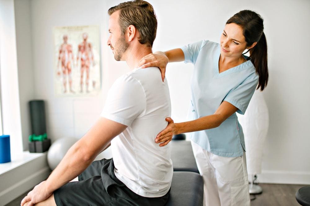 A chiropractor is examining a man to determine treatments to improve mobility. 