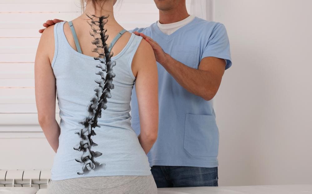 A chiropractor is helping a woman ease the symptoms of adult scoliosis. 