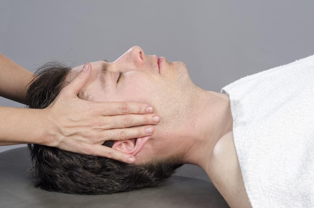 A man is being treated by a chiropractor for trigeminal neuralgia pain.