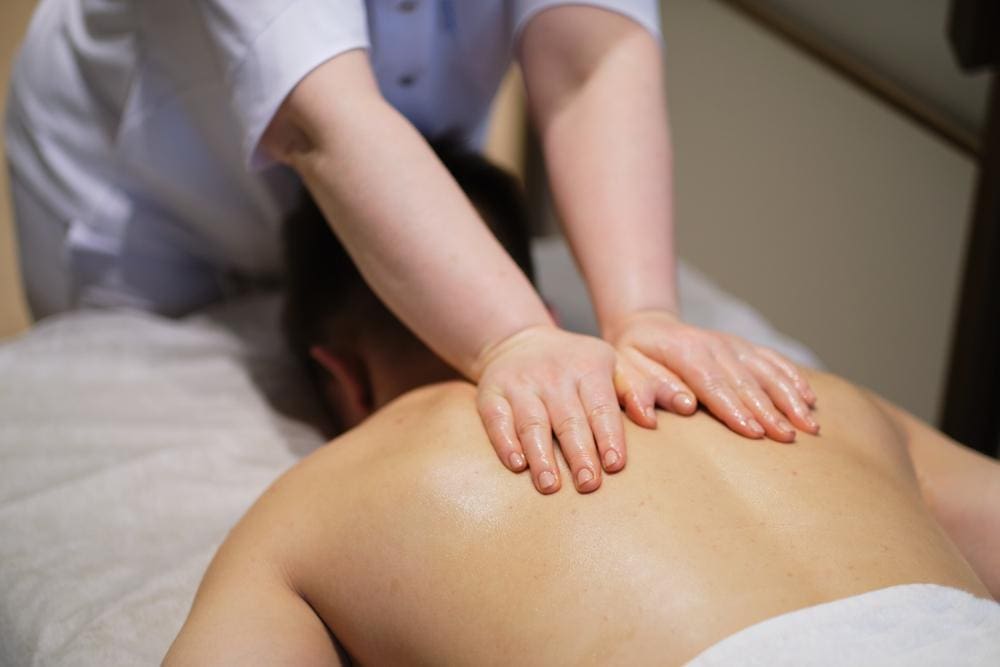A chiropractor is administering therapeutic massage to improve mobility. 