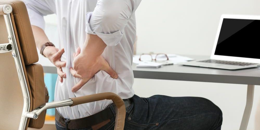 A man is having lower back pain because of degenerative disc disease.