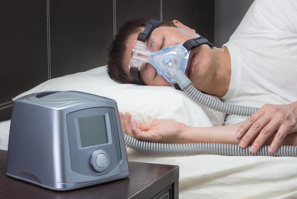 A man with sleep apnea is using a machine to sleep through the night.