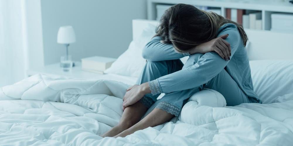 A woman is suffering from depression and can't get out of bed.