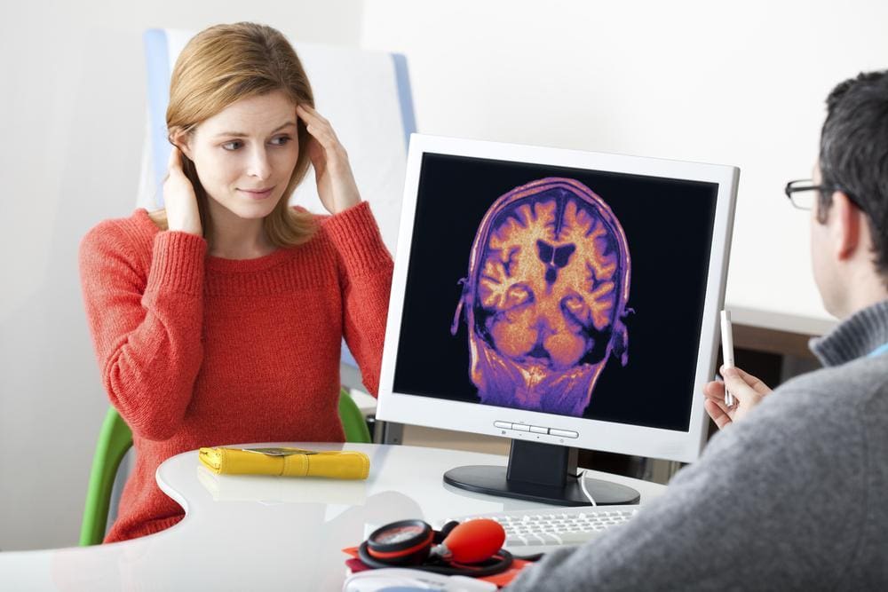 A woman and her doctor are looking at a brain scan..