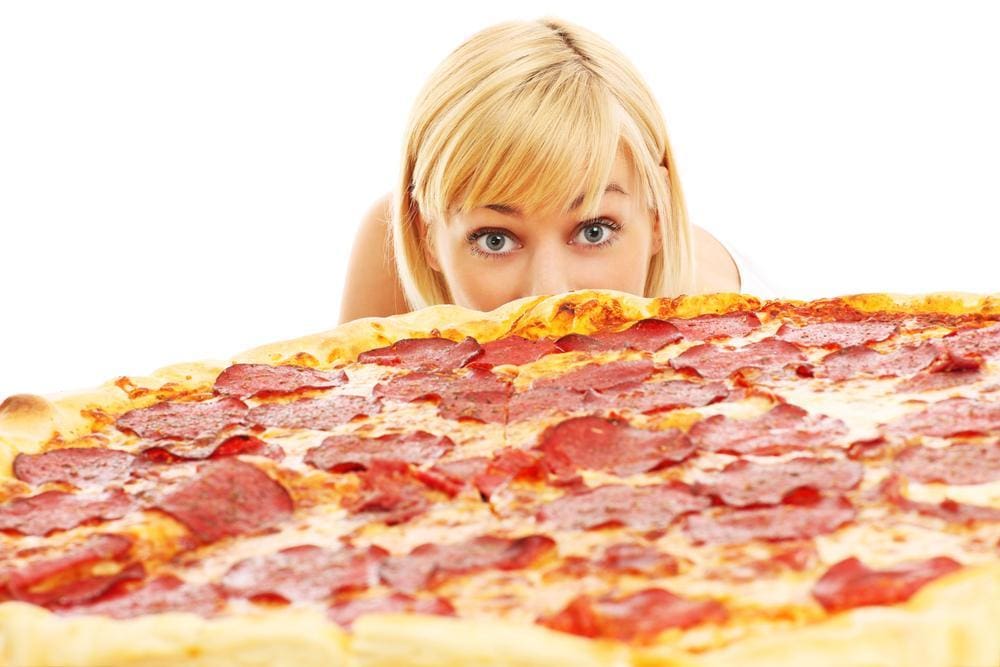 A woman is lusting over pizza.