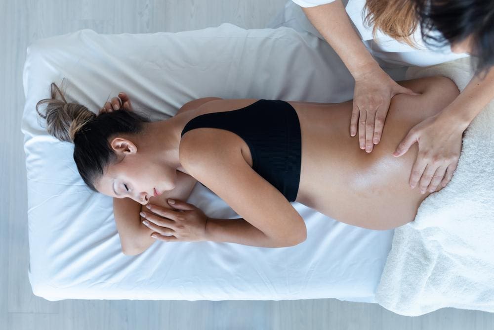 Young pregnant woman receiving prenatal spinal adjustment.

