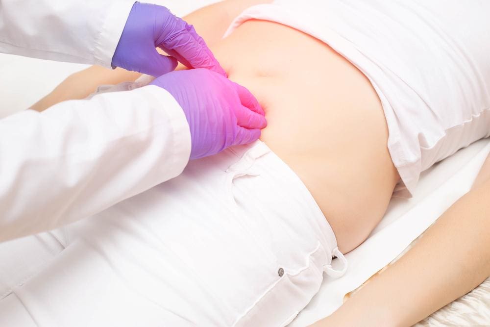 Doctor examining the abdomen of a patient. 