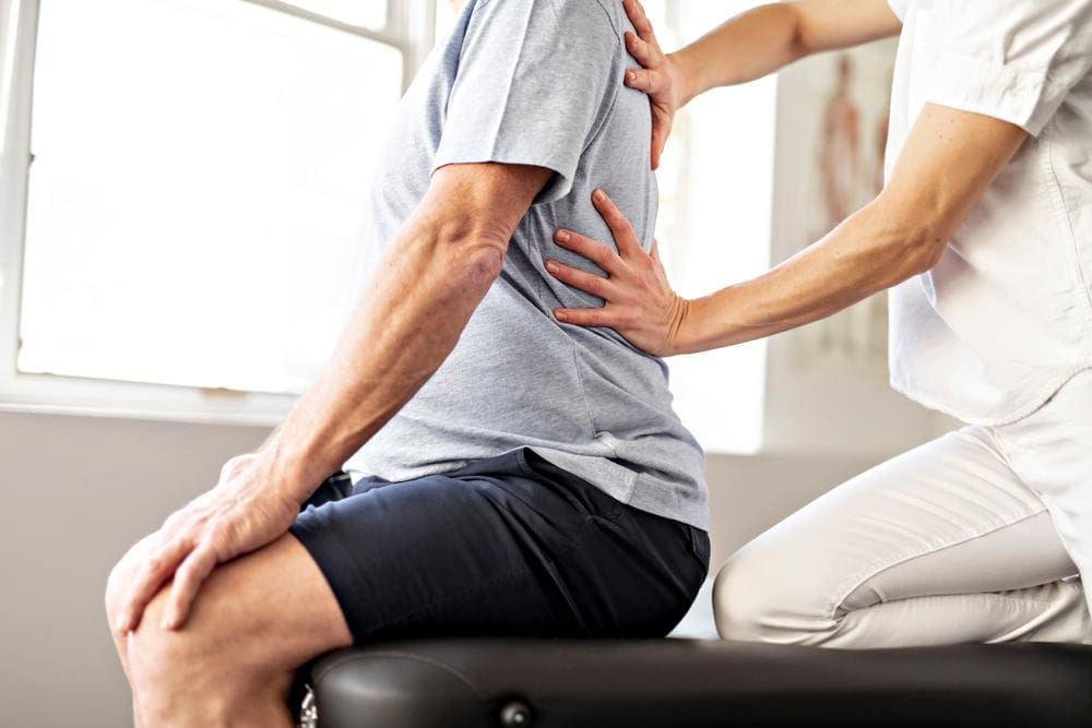 Man receives spinal manipulation from a chiropractor.