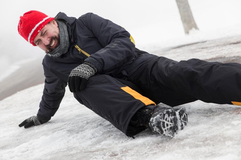 Man has a slip and fall accident on an icy street.